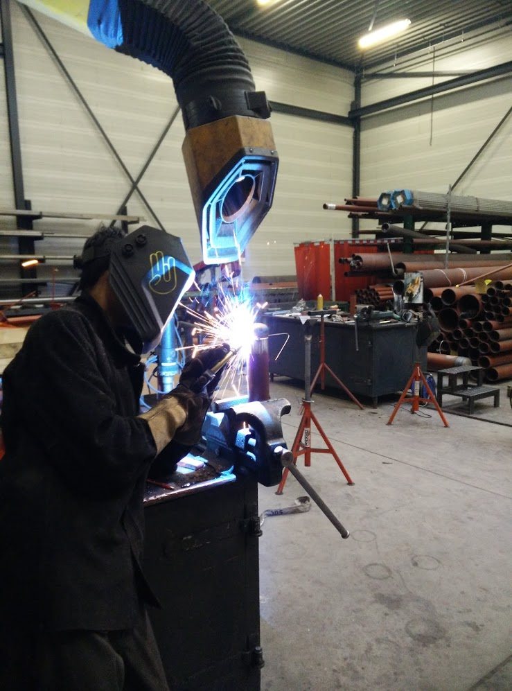Lasser met blauwe lasboog en vonken — vakmanschap in ons team
